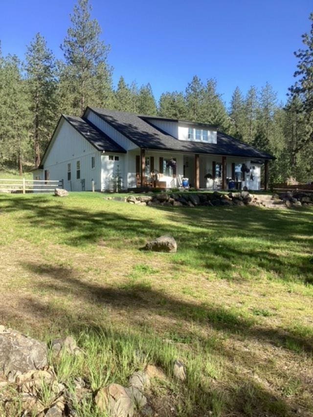 back of house featuring a lawn and fence