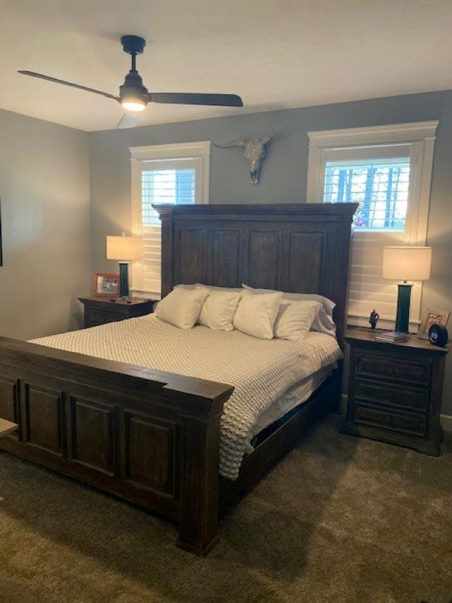 bedroom with dark colored carpet and ceiling fan