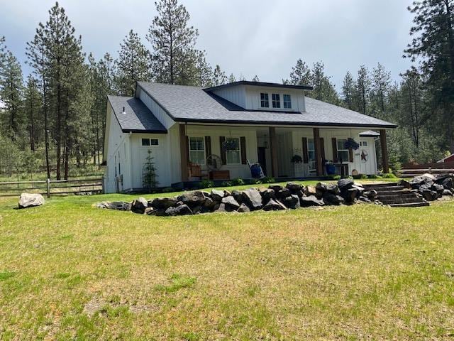 view of front of home with covered porch, a front yard, and fence