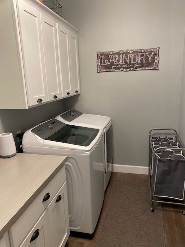 washroom featuring baseboards, cabinet space, and washing machine and dryer