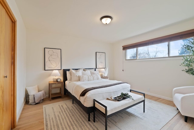 bedroom with light wood-type flooring and baseboards