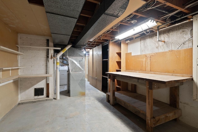 unfinished basement with washer / dryer and a workshop area