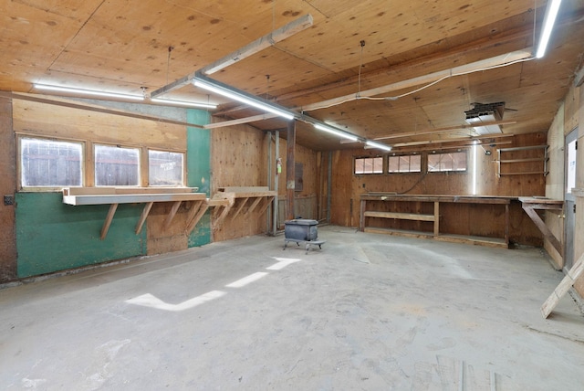 miscellaneous room featuring a workshop area and unfinished concrete flooring