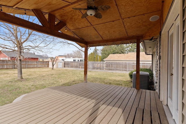 wooden terrace with a lawn, central AC, a fenced backyard, and a storage shed