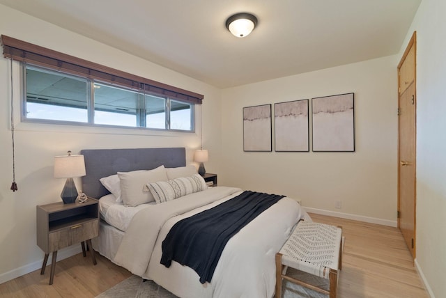 bedroom featuring baseboards and light wood-style floors