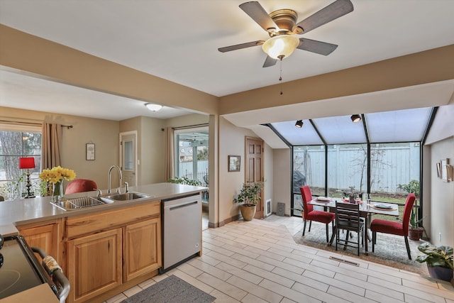 kitchen featuring dishwasher, ceiling fan, range, and a sink