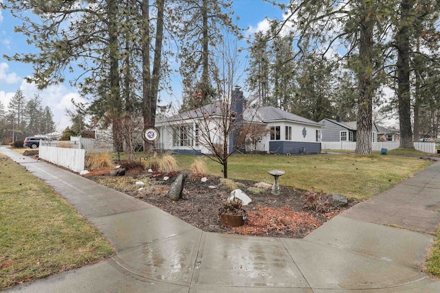 single story home with a front lawn, fence, and a chimney