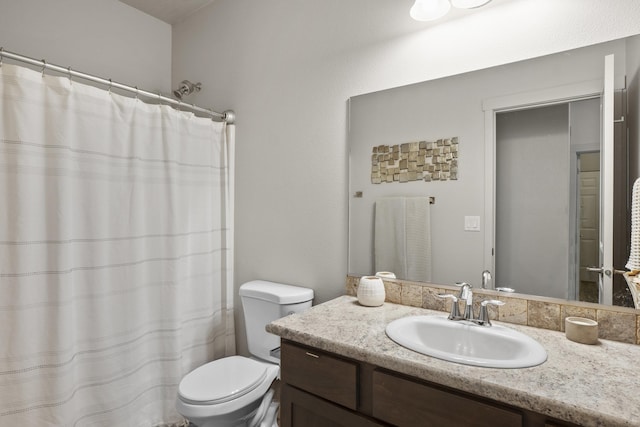 bathroom featuring curtained shower, toilet, and vanity