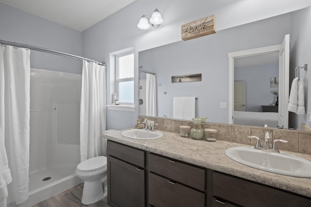 full bath featuring double vanity, toilet, a shower with curtain, and a sink