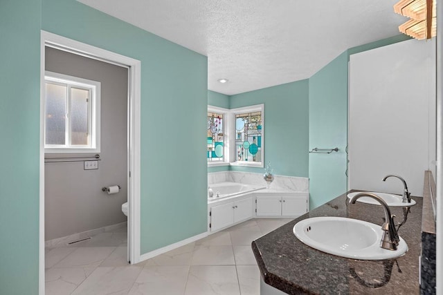 full bath with a sink, a textured ceiling, a bath, and toilet