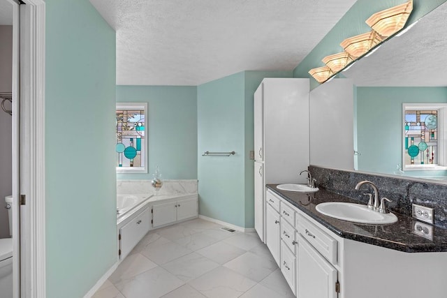 bathroom with a textured ceiling, toilet, marble finish floor, and a sink