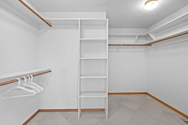 spacious closet with visible vents and marble finish floor