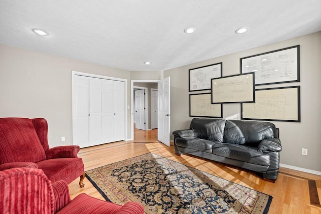 living room with recessed lighting, baseboards, and wood finished floors