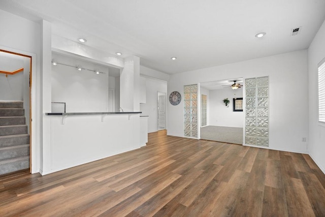 unfurnished living room featuring stairway, wood finished floors, a ceiling fan, visible vents, and recessed lighting