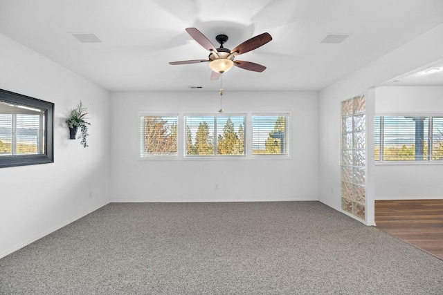 carpeted empty room with baseboards, a healthy amount of sunlight, and a ceiling fan