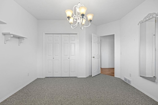 unfurnished bedroom featuring a chandelier, visible vents, baseboards, and carpet floors