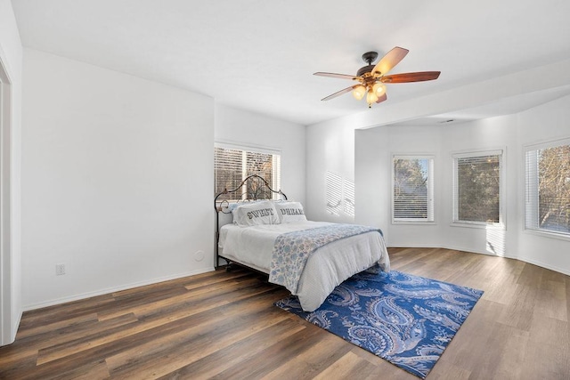 bedroom with ceiling fan, baseboards, and wood finished floors