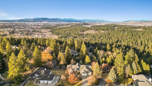 aerial view featuring a wooded view and a mountain view