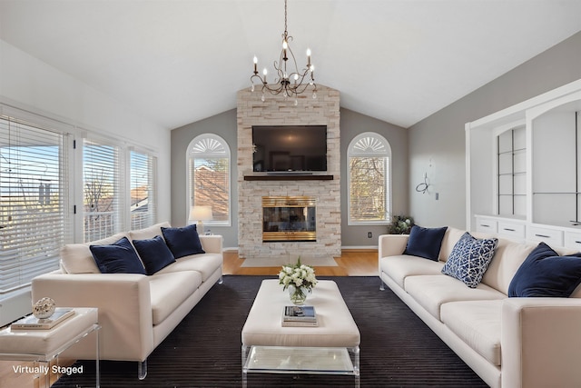 living room featuring a notable chandelier, wood finished floors, a fireplace, baseboards, and vaulted ceiling