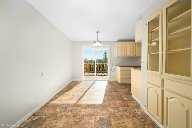 unfurnished dining area featuring stone finish flooring and baseboards