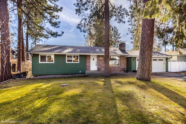 single story home with fence, a front yard, a chimney, driveway, and an attached garage