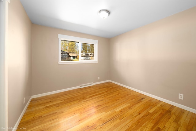 unfurnished room featuring visible vents, light wood-style floors, baseboards, and baseboard heating