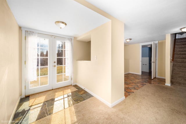 doorway to outside featuring stone tile flooring, french doors, carpet, baseboards, and stairs