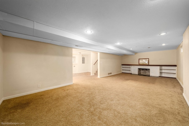 finished basement with a brick fireplace, stairway, baseboards, and carpet floors