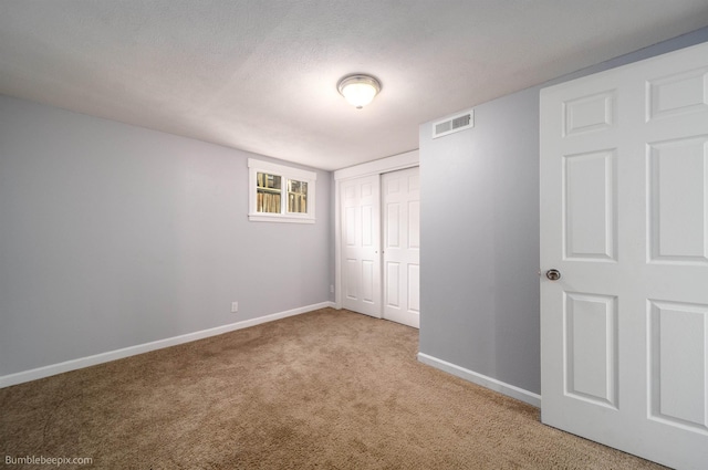 unfurnished bedroom with visible vents, baseboards, carpet floors, a closet, and a textured ceiling