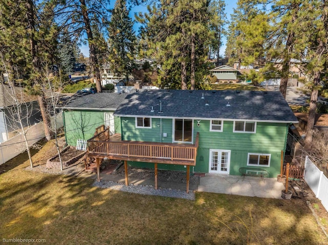 rear view of property featuring a patio area, a lawn, a wooden deck, and a fenced backyard