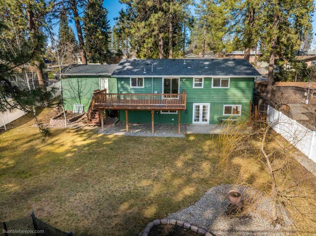 back of house featuring stairway, a wooden deck, a yard, a fenced backyard, and french doors