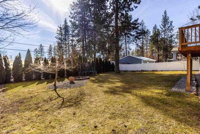 view of yard featuring a trampoline and fence