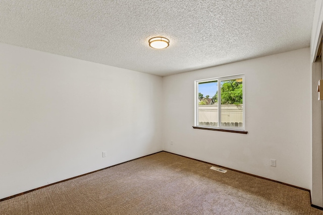 empty room featuring visible vents, baseboards, and carpet floors