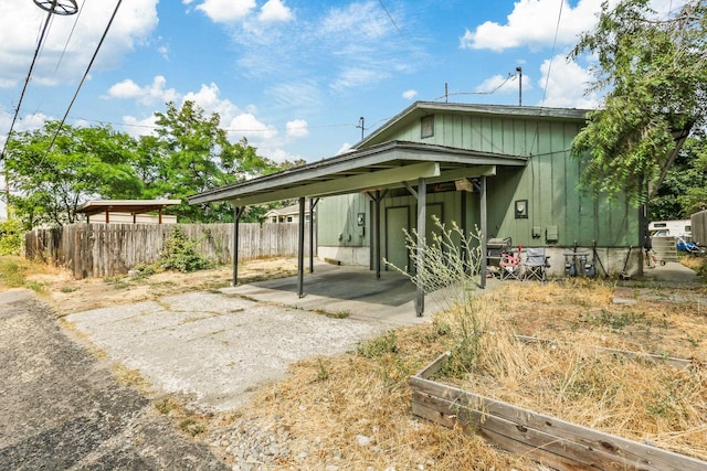 exterior space featuring a carport, fence, and driveway