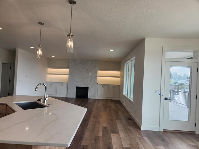 8712 E Ridgeline Ln, Spokane, WA 99217 - kitchen featuring light stone countertops, wood-type flooring, recessed lighting, decorative light fixtures, and a fireplace