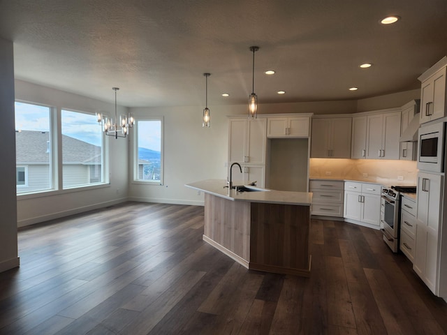 8712 E Ridgeline Ln, Spokane, WA 99217 - kitchen featuring gas range, built in microwave, a chandelier, dark wood-style flooring, and recessed lighting