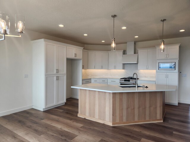 8712 E Ridgeline Ln, Spokane, WA 99217 - kitchen with appliances with stainless steel finishes, custom exhaust hood, light countertops, dark wood-style flooring, and white cabinetry