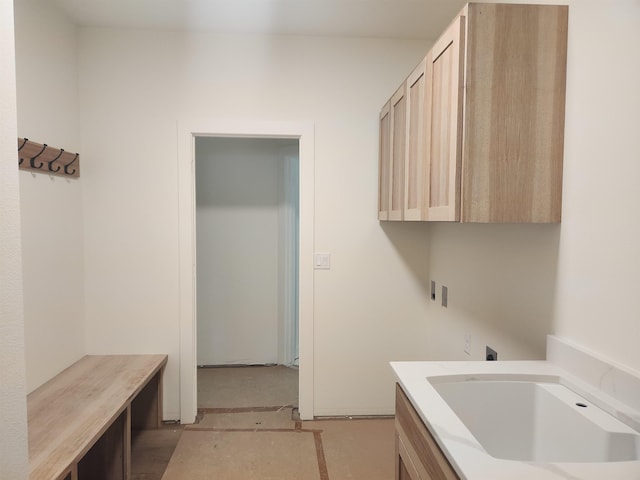 washroom with cabinet space, hookup for an electric dryer, hookup for a washing machine, and a sink