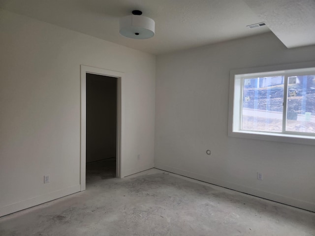 unfurnished room featuring visible vents, concrete floors, and baseboards