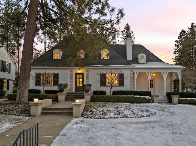 view of front of home featuring stucco siding and a chimney