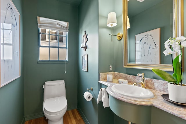 bathroom with baseboards, toilet, wood finished floors, and vanity