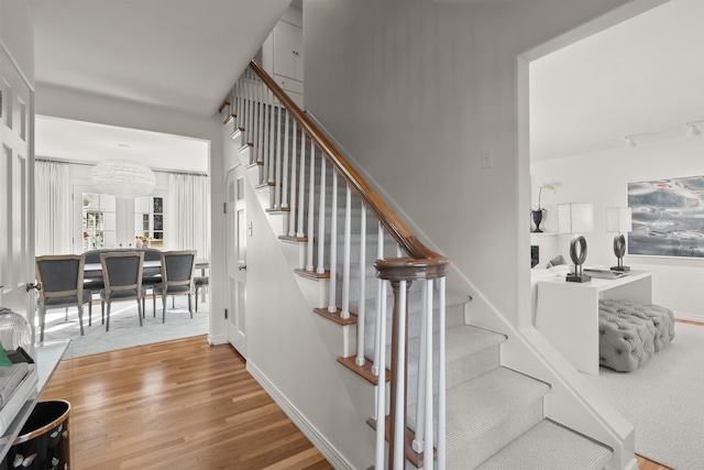 stairway with wood finished floors and baseboards