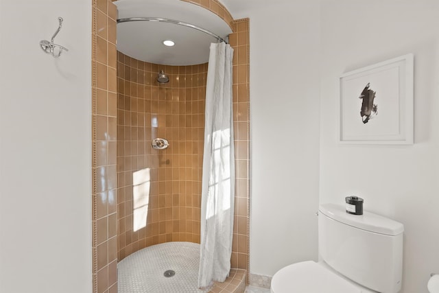 bathroom with toilet and a tile shower