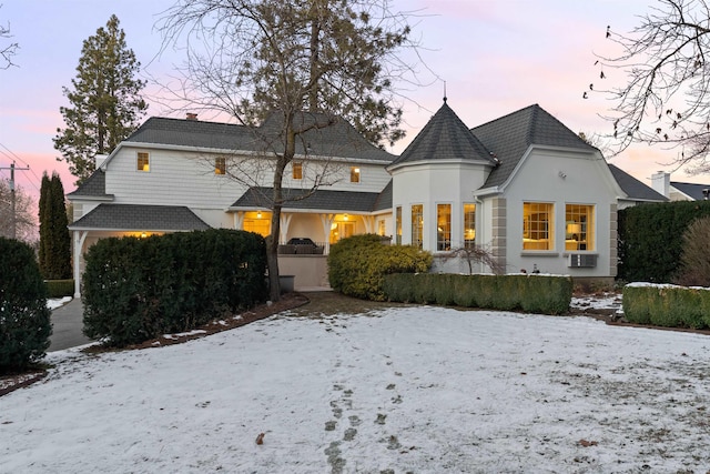 snow covered property with stucco siding