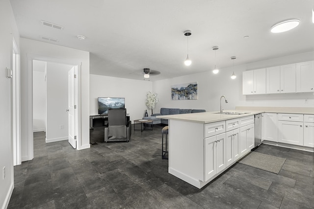 kitchen featuring visible vents, a sink, white cabinetry, a peninsula, and dishwasher