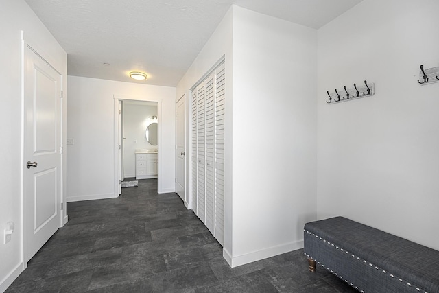 hallway featuring baseboards and a textured ceiling