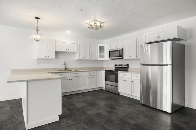 kitchen with a sink, white cabinetry, appliances with stainless steel finishes, a peninsula, and light countertops