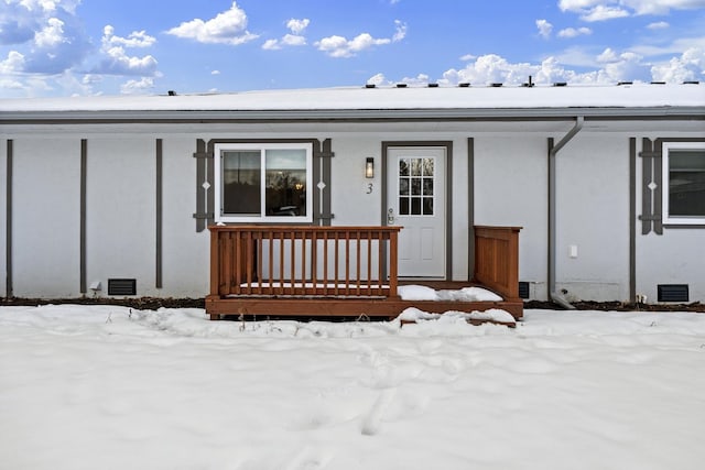 snow covered property entrance with a porch and crawl space