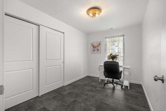 office area with baseboards, visible vents, and a textured ceiling