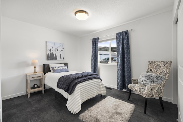 bedroom featuring a textured ceiling and baseboards